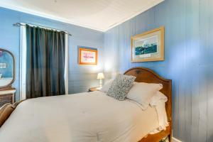 a bedroom with a white bed with blue walls at 10 Mi to Cape Lookout Ferry Serene Coastal Escape in Marshallberg