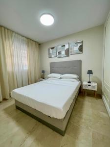 a bedroom with a large white bed in a room at Beachside Vacation Apartment in Casares Playa in San Luis de Sabinillas