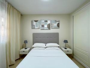 a bedroom with a large white bed with two night stands at Beachside Vacation Apartment in Casares Playa in San Luis de Sabinillas +28 photos