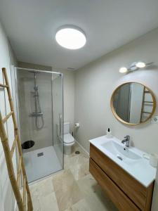 a bathroom with a shower and a sink and a mirror at Beachside Vacation Apartment in Casares Playa in San Luis de Sabinillas