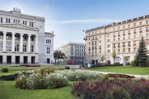 a group of buildings and a park with flowers at Grand Hotel Kempinski Riga in Rīga