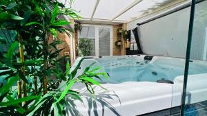 a jacuzzi tub in a room with plants at Modern and luxury vacation house, private Jacuzzi in Zoetermeer