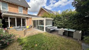 a patio with couches and a table in a yard at Modern and luxury vacation house, private Jacuzzi in Zoetermeer