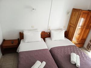 two beds in a small room with at Eleni's Rooms in Samothraki