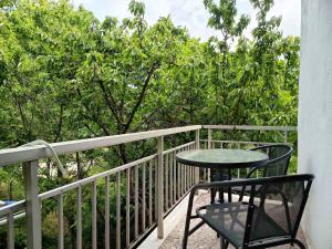 a table and chairs on a balcony with trees at Eleni's Rooms in Samothraki