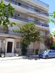 una macchina blu parcheggiata di fronte a un edificio di Sea and Sun Erato Studios a Loutra Edipsou