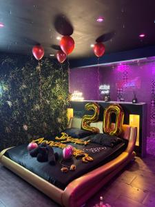 una stanza con un letto con palloncini e un numero di Spazuroom Luxury Suite a Mouscron