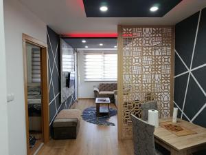 une pièce avec une table et un salon avec un mur dans l'établissement Golden Luxury Neom apartman, Stup, Sarajevo, à Sarajevo 36 autres photos