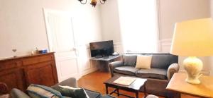 a living room with a couch and a tv at Family home Cour du Louvre in Saint-Sever-Calvados +23 photos