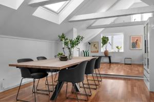 ein Esszimmer mit einem großen Holztisch und Stühlen in der Unterkunft Arctic Homes - Historic Penthouse in Tromsø + 19 Fotos