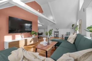 ein Wohnzimmer mit 2 grünen Sofas und einem Tisch in der Unterkunft Arctic Homes - Historic Penthouse in Tromsø