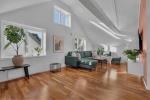 ein Wohnzimmer mit Sofa und Tisch in der Unterkunft Arctic Homes - Historic Penthouse in Tromsø