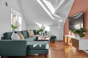 ein Wohnzimmer mit Sofa und Fernseher in der Unterkunft Arctic Homes - Historic Penthouse in Tromsø