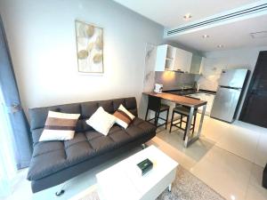 a living room with a couch and a table at EMERALD TERRACE CONDO 52-FAMILY 1 Bedroom POOL VIEW in Patong Beach
