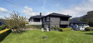 a black house with cars parked in front of it at Haugane in Selje