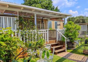 a tiny house with a white fence and a porch at Mobile Fontana Oasis in Castelnuovo del Garda