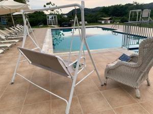 a swing bed and chairs next to a swimming pool at Family Garden in Sidari