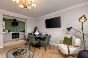 a living room with a table and chairs and a television at Emerald Suite, The Stirling Residence in Stirling