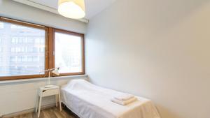 una stanza bianca con un letto e una finestra di Spacious Apartment for 3 a Riihimäki