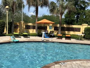 a swimming pool with chairs and a table and an umbrella at La Quinta Inn and Suites by Wyndham, Ocala in Ocala