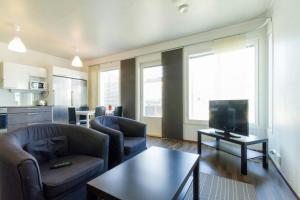 a living room with two chairs and a tv at Spacious Apartment for 8 with Sauna in Kerava
