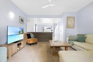 a living room with a couch and a tv at The Queenslander - Full Moon Terrace in Port Douglas