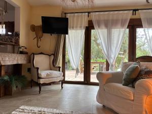 a living room with a couch and a tv and sliding glass doors at Casita Balear Sa Coveta in Algaida