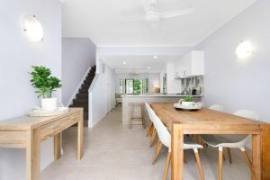 a kitchen and dining room with a wooden table and chairs at The Queenslander Family Townhouse Near Four Mile Beach in Port Douglas