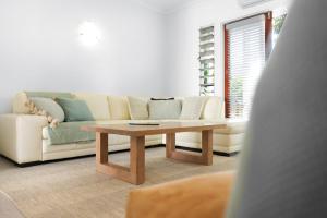 a living room with a couch and a coffee table at The Queenslander Family Townhouse Near Four Mile Beach in Port Douglas +14 photos