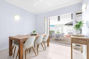 a dining room with a wooden table and chairs at The Queenslander Family Townhouse Near Four Mile Beach in Port Douglas