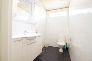 a white bathroom with a sink and a toilet at Spacious Apartment for 8 with Sauna in Kerava +10 photos
