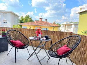 un patio con 2 sillas y una mesa con almohadas rojas en Art&Castle View 5 min from Sigurtà Park, en Valeggio sul Mincio