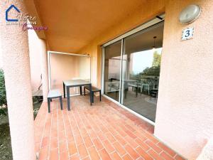 a patio with a table and a glass window at L'Empereur Colliourenc in Collioure