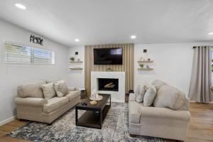 a living room with two chairs and a fireplace at Boho on Bermuda By Rather Be Properties in Tucson