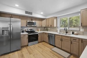 a kitchen with wooden cabinets and stainless steel appliances at Boho on Bermuda By Rather Be Properties in Tucson