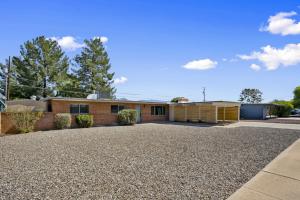 a house with a gravel driveway in front of it at Boho on Bermuda By Rather Be Properties in Tucson
