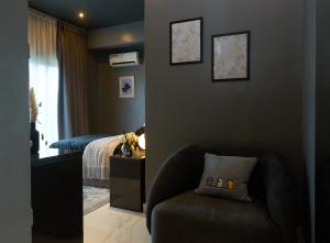 a bedroom with a bed and a chair and a chair at Dark Apartment in Lekki in Lagos