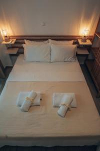 a bed with two folded towels on top of it at Summer Pearl Paralia Ofrinio in Ofrínion