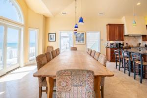 a kitchen and dining room with a large wooden table and chairs at Oceanfront Estate with private pool and hot tub in North Topsail Beach