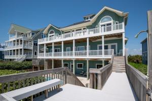 a house on the beach with a boardwalk at Oceanfront Estate with private pool and hot tub in North Topsail Beach