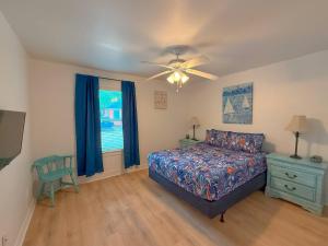 una camera da letto con un letto e un ventilatore a soffitto di Going Coconuts By The Pool a Rockport Altre 19 foto