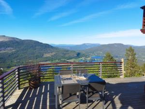 a table on a deck with a view of mountains at Weitblicken - Cosy Holiday Home with stunning views in Vradal