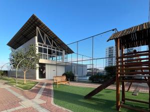 a playground in front of a building with a slide at 2Qts, 6km do Parque do Povo in Campina Grande