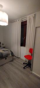une chambre avec un lit et une chaise rouge dans l'établissement Casa David y Nina, à Sestao
