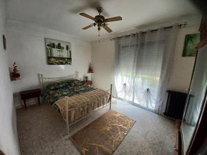 a bedroom with a bed and a ceiling fan at La madeleine in Caussade