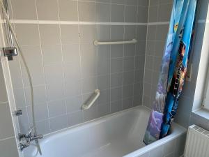 a bathroom with a bath tub with a shower curtain at Zuhause auf Zeit in zentraler Lage am Flughafen Leipzig in Schkeuditz