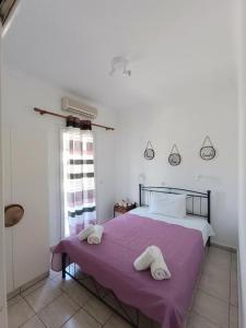 a bedroom with a bed with towels on a purple blanket at Anna'sHouse in Agios Ioannis