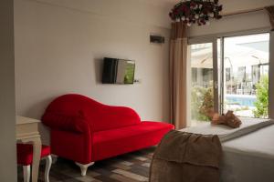 a living room with a red chair and a window at La Vida otel in Urla