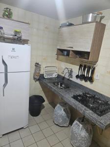 a kitchen with a sink and a white refrigerator at Cozy Apto Praia do Morro in Guarapari