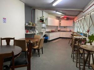 a restaurant with tables and chairs and a kitchen at Hostel JF in Sao Paulo
